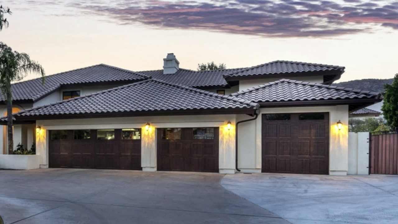 Phoenix home after a Hochuli garage addition with custom dark wood doors and reworked roof line by Hochuli Design and Remodeling Team