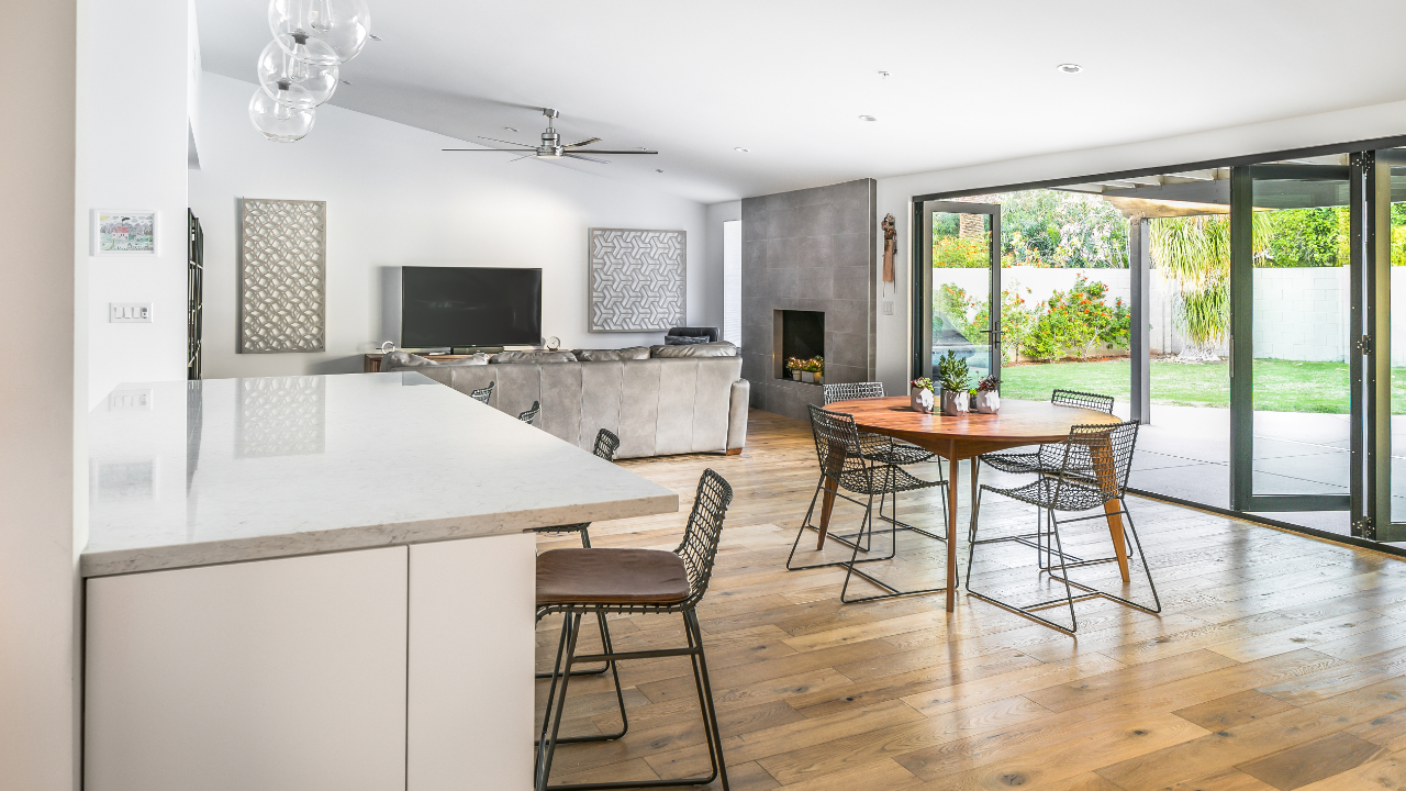 Premium whole house remodel in Scottsdale featuring open-plan kitchen flowing to dining and living spaces with indoor-outdoor connection by Hochuli Design and Remodeling Team