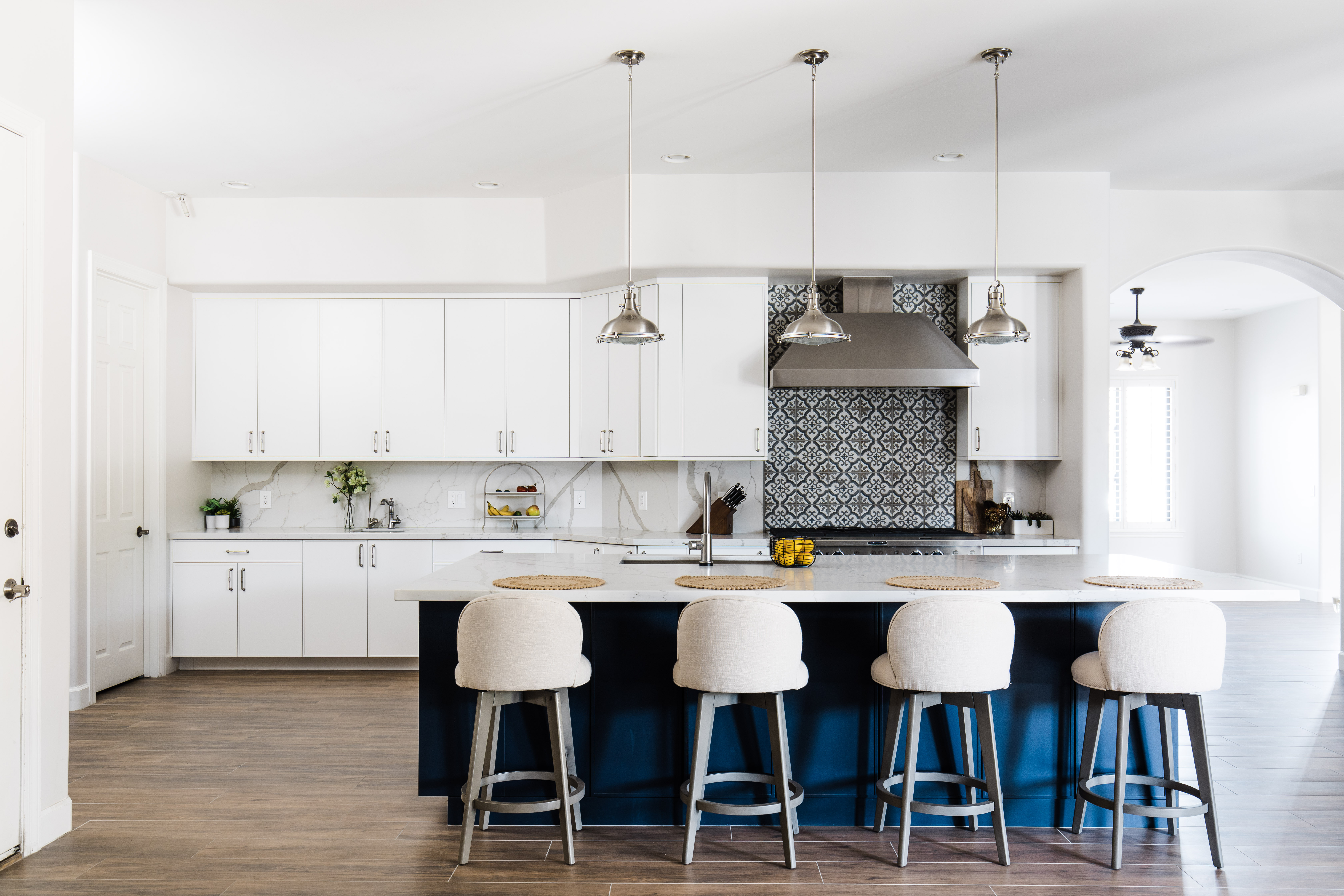 Premium kitchen remodel in Mesa featuring navy island, custom encaustic tile backsplash, white perimeter cabinets and bar seating by Hochuli Design and Remodeling Team