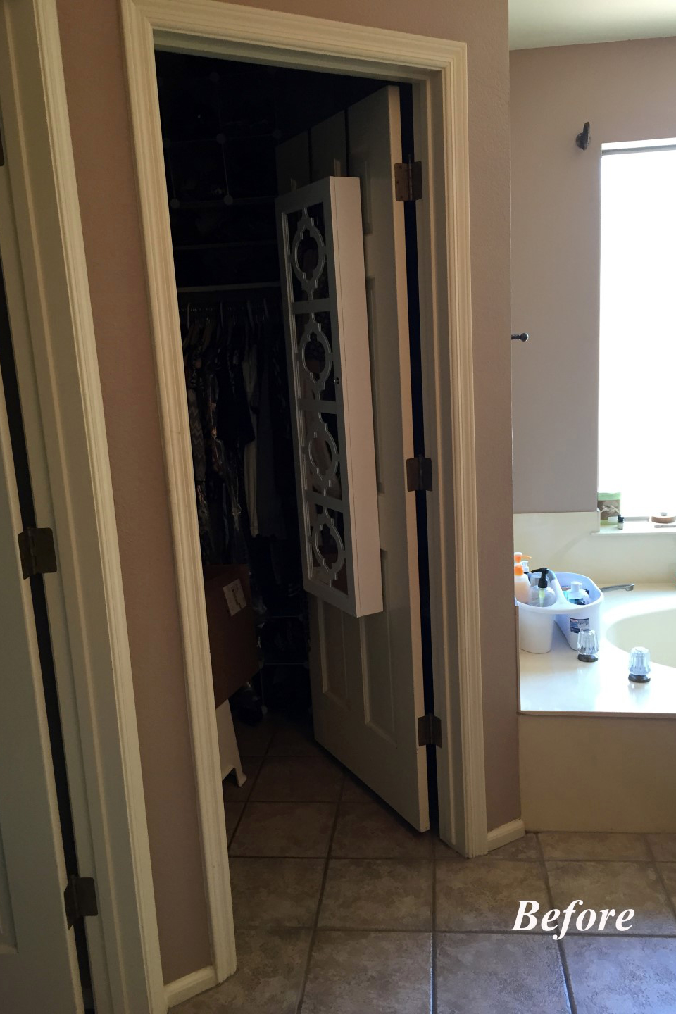 Looking through one of the original closet doorways at the Tempe bathroom, with the old cultured marble tub visible beyond, showing the cramped layout that left useful square footage as wasted space.