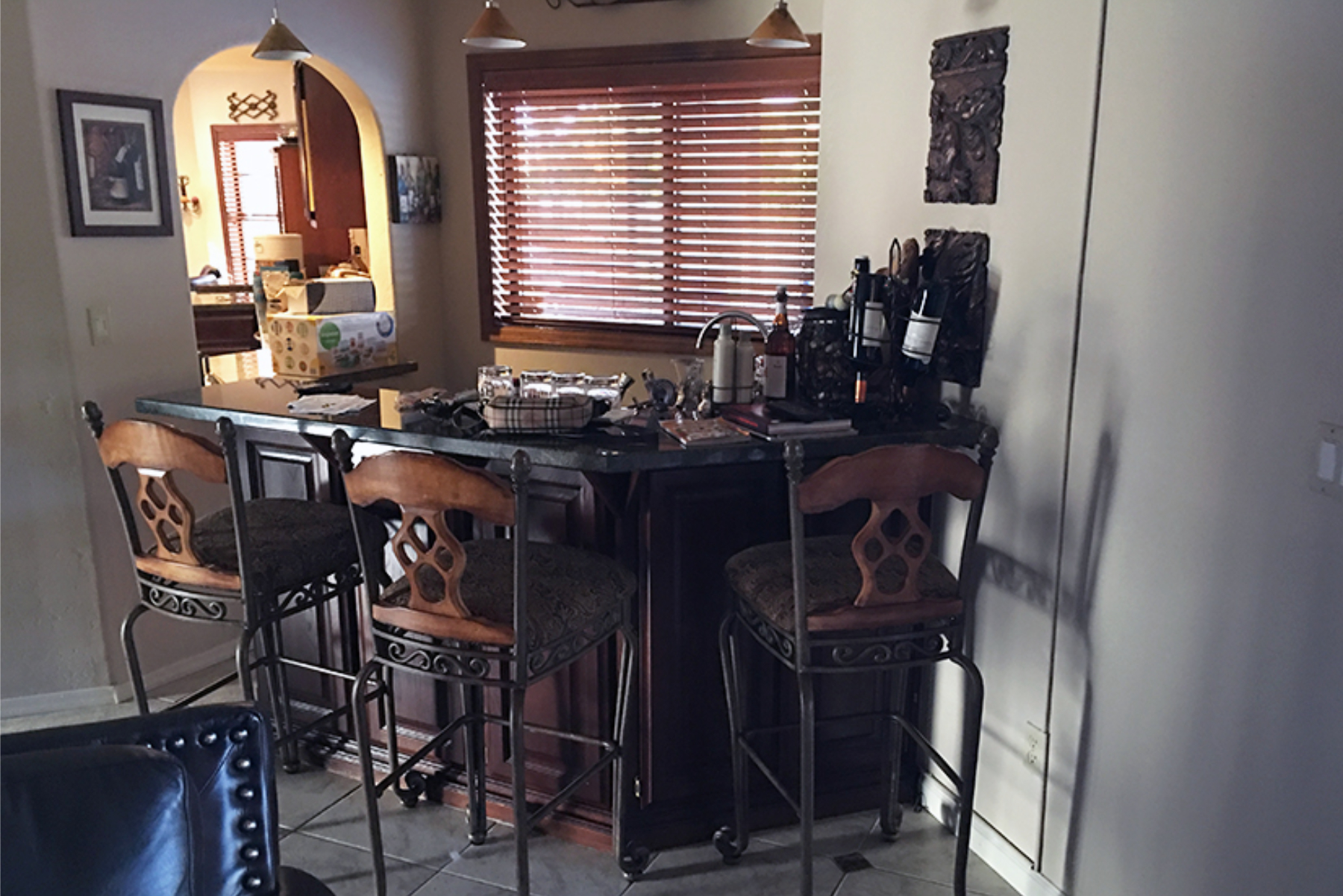 Original closet bar area with dark cabinets, wood blinds, and tile floor in the Phoenix home before the kitchen remodel.