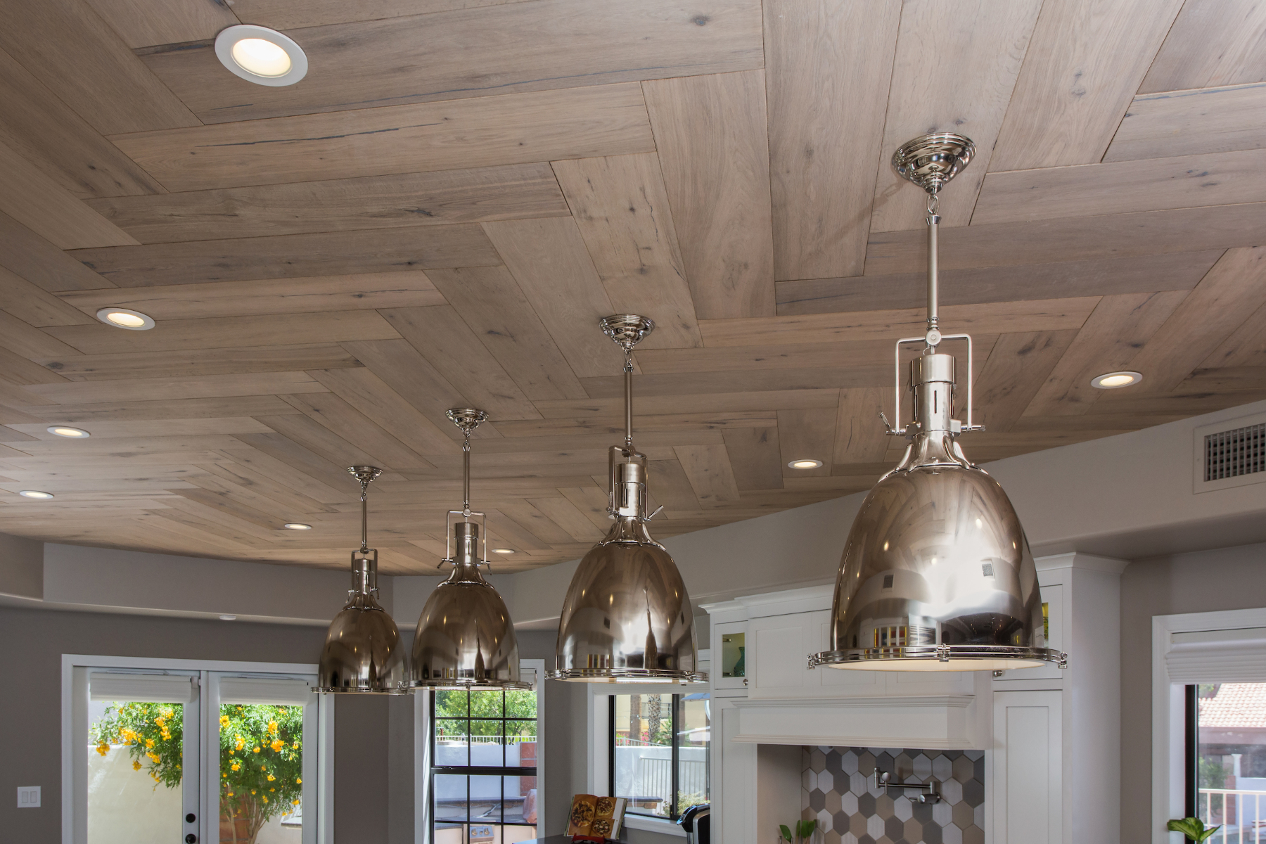 New French White Oak ceiling installed in herringbone pattern at the Phoenix kitchen, with chrome pendants and recessed lighting.