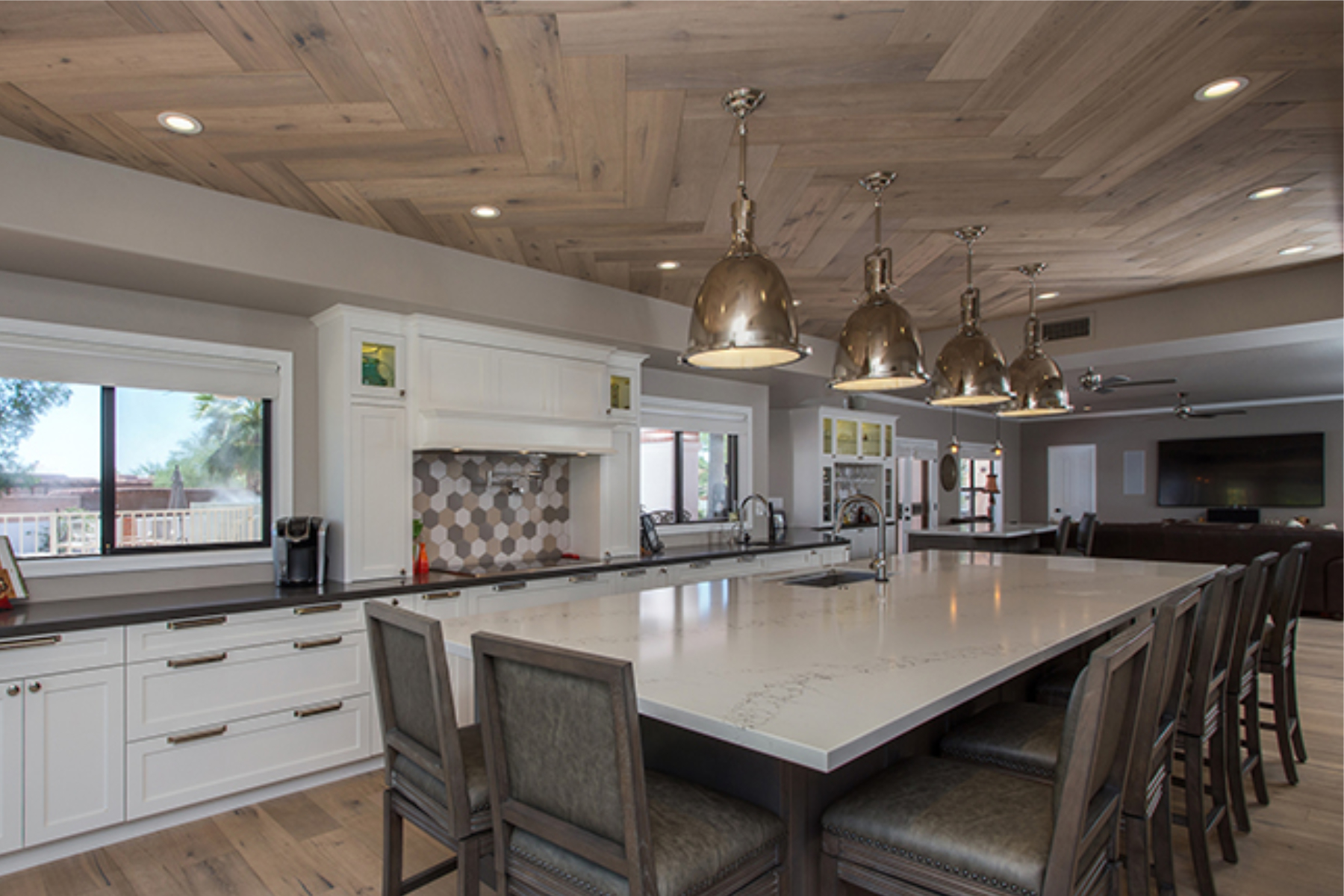 New Phoenix kitchen with large center island, white shaker cabinets, stained island base, herringbone wood ceiling, and chrome pendant lights.