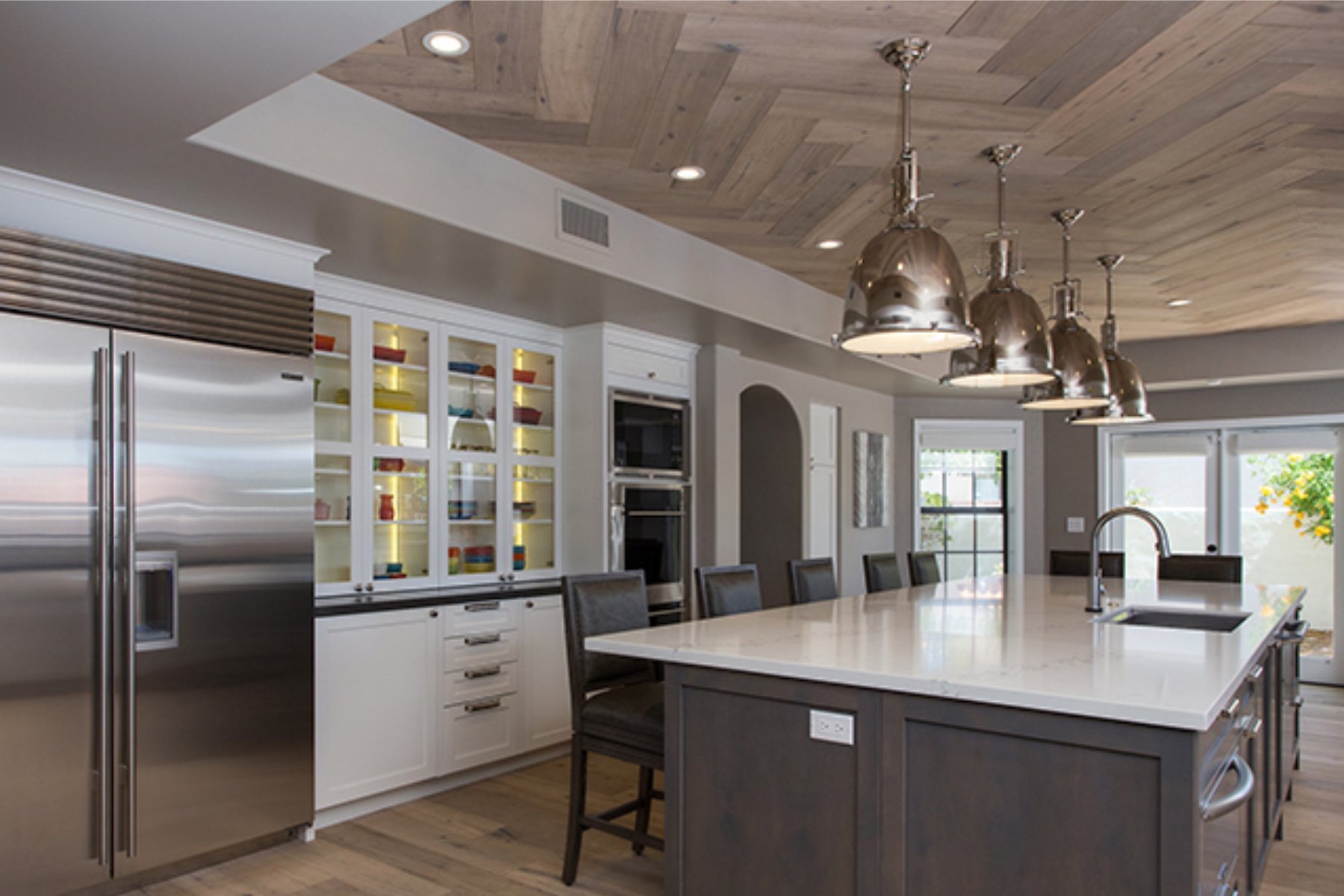 New cooktop wall at the Phoenix kitchen showing white shaker cabinets, custom hood, Walker Zanger KNIT tile backsplash, and Delta pot filler above the cooktop.