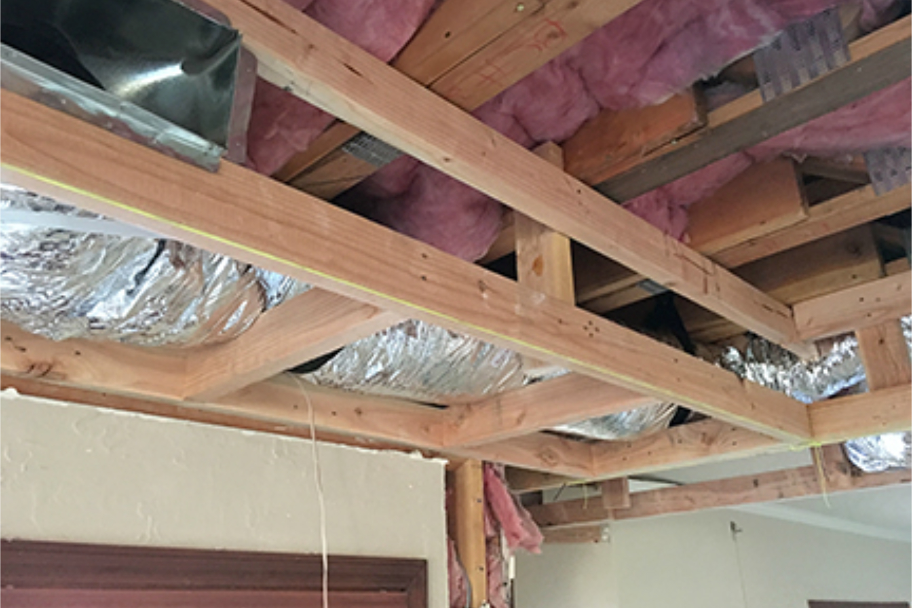 Soffit framing at the Phoenix wood-ceiling kitchen wrapping the perimeter to conceal HVAC and electrical components.